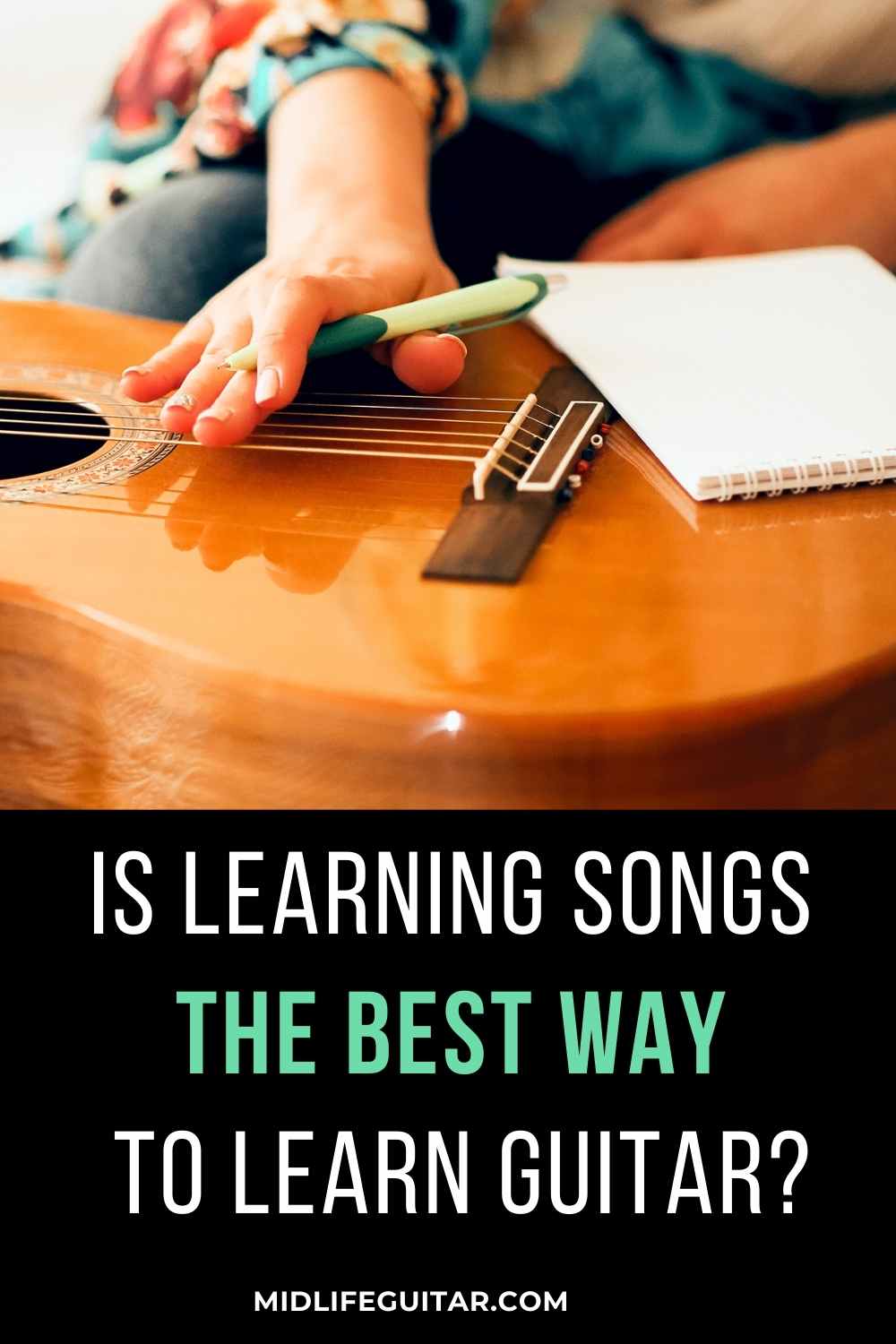 A woman writing songs on a piece of paper resting on a guitar